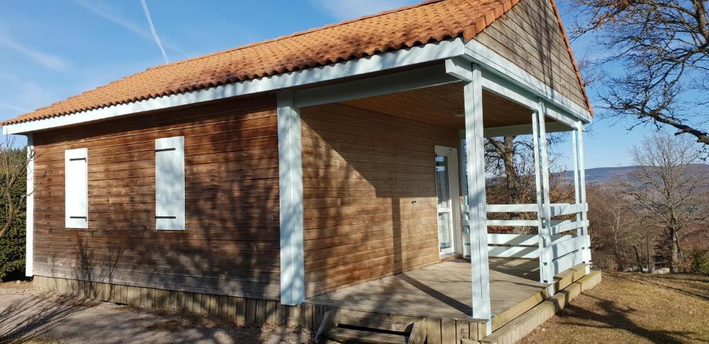 a small wooden building with a porch at 18 Chalet Myosotis in Blavignac