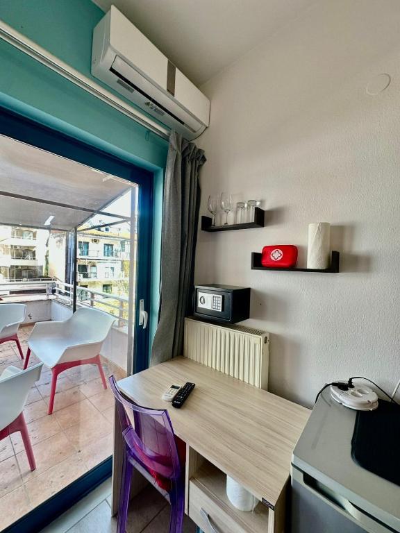 a kitchen with a table and chairs and a balcony at Petit City in Orestiada