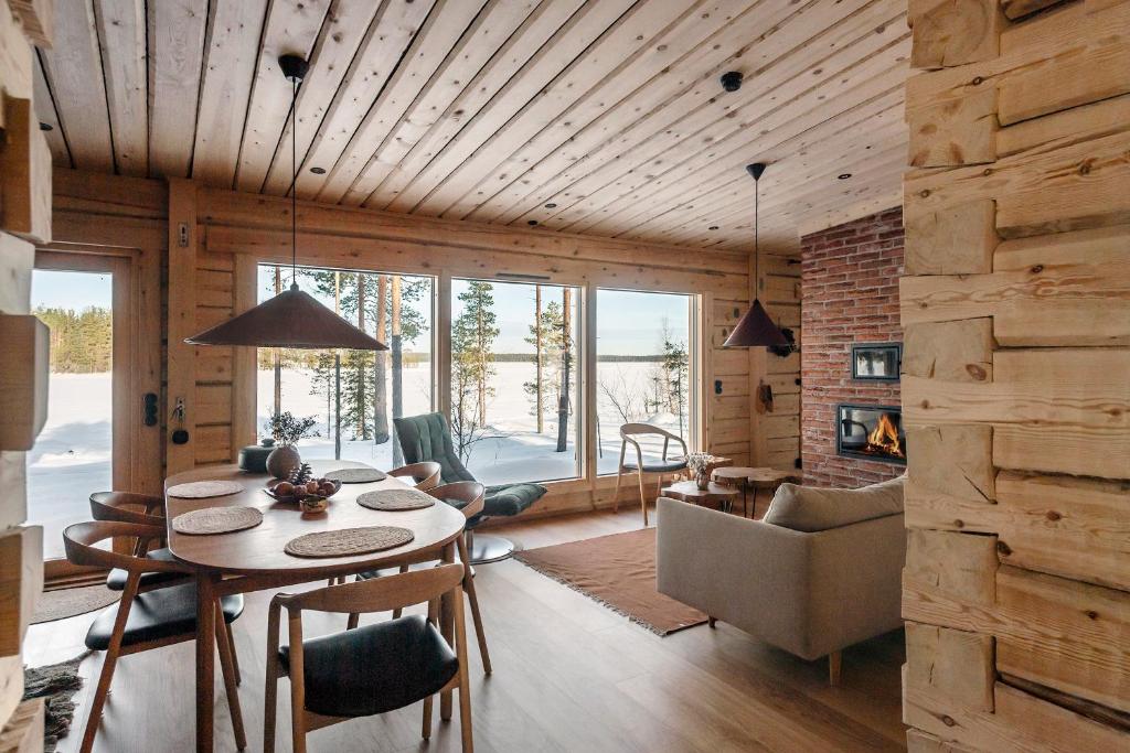 a room with a table and chairs and a living room at Aurora Atelier Onnela in Rovaniemi