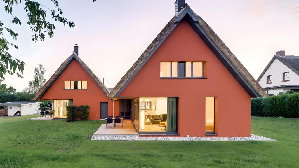 an orange house with a black roof at Ferienhaus Wreechen 25, Haus 2 in Putbus