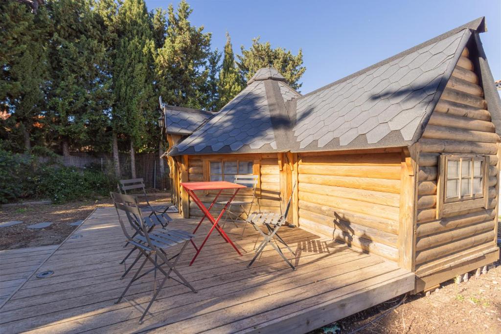 a cabin with a red table and chairs on a deck at Kota Crème Catalane in Saint-André