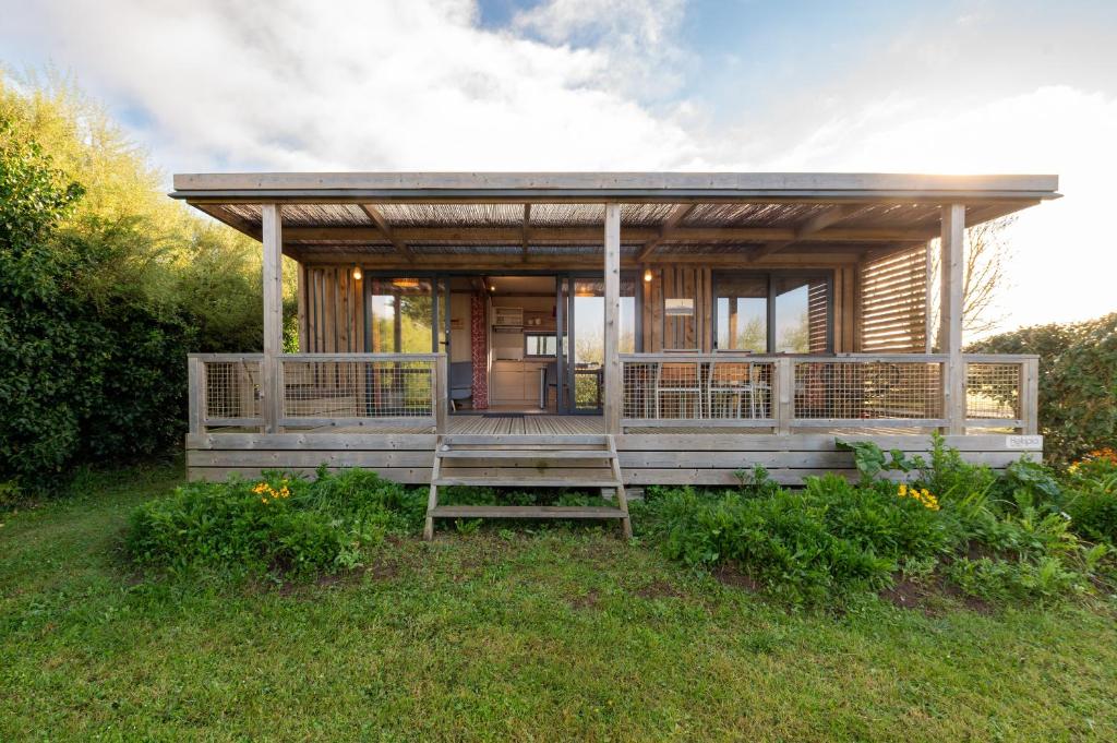 a small wooden house with a large porch at Chalet 30m2 - Ouessant in Plouhinec