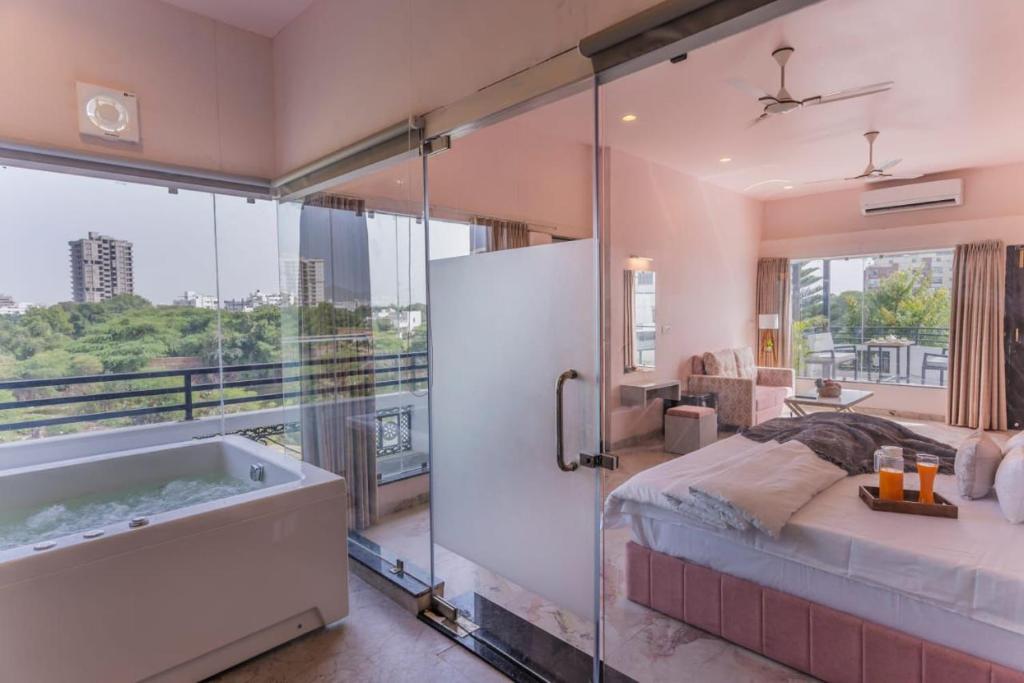 a large bathroom with a tub and a bed and a bedroom at Aara-boutique stay udaipur in Udaipur