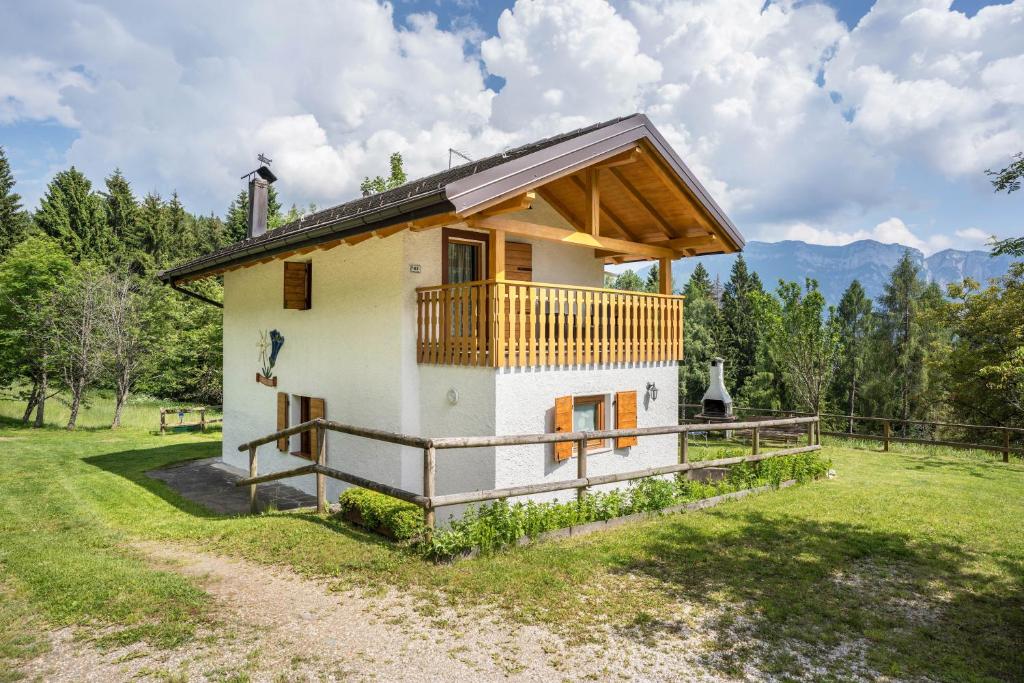 a small house with a balcony on a field at Baita Bocheto in Levico Terme