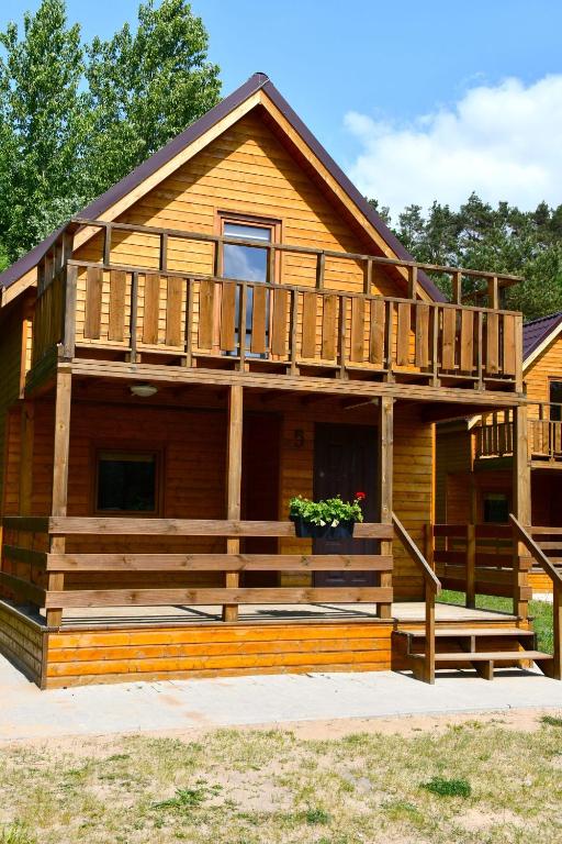 a log cabin with a porch and a deck at Ośrodek Rekreacyjno-Wypoczynkowy Żuczek, Debrzno in Debrzno