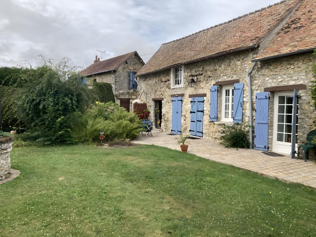 a house with blue doors and a yard at Chambre D'hôtes - Chambre in Jeufosse