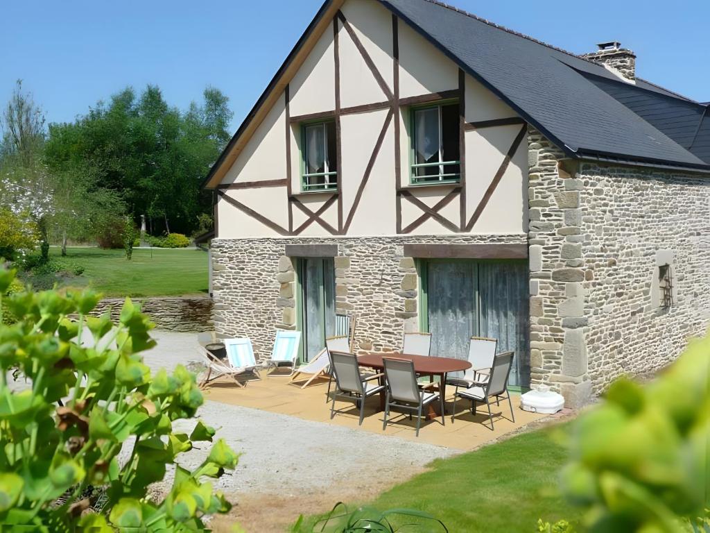 a house with a table and chairs in front of it at Les Hortensias - Gîtes in La Croix-Helléan