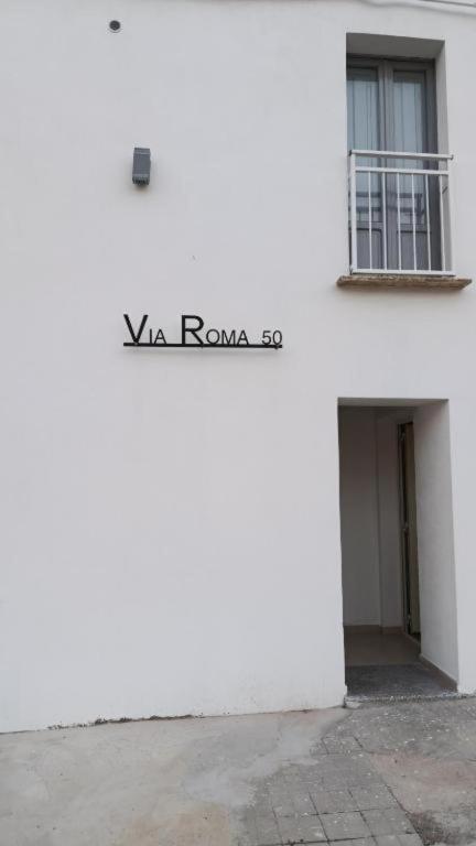 a white building with the word wa roma on it at Via Roma 50 in Bacu Abis