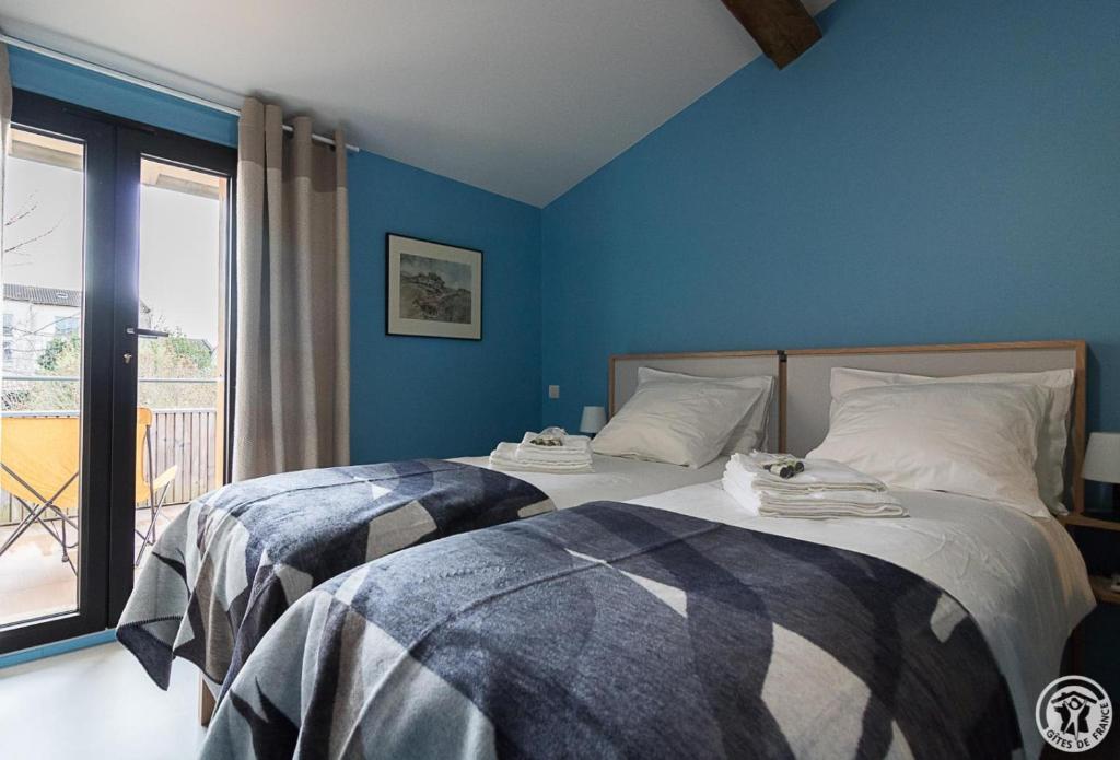 two beds in a bedroom with blue walls at Chambre d'hôtes oyasumi in Muret
