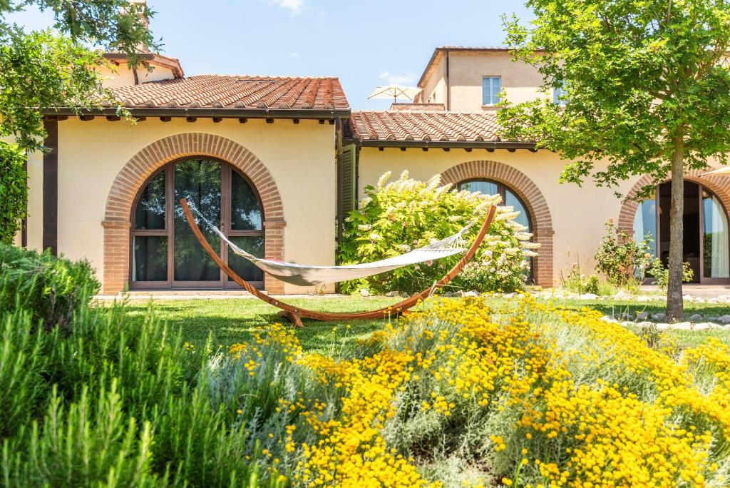 a hammock in a garden in front of a house at Villa Aquila in Trequanda