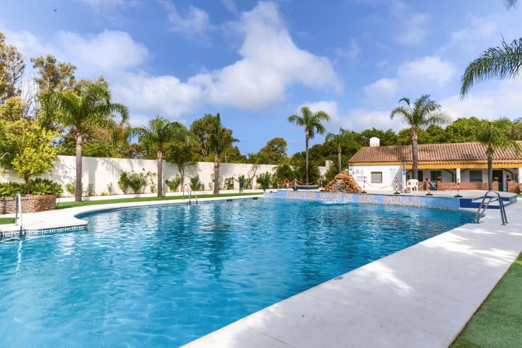 a large swimming pool with blue water at Kampaoh Conil in Conil de la Frontera