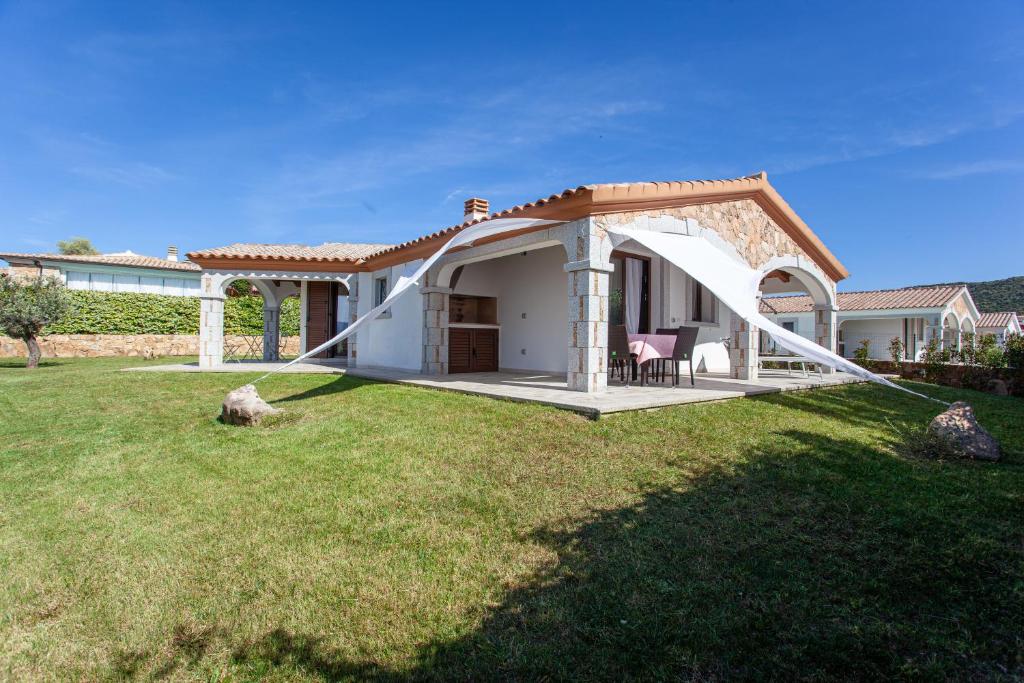 a white house with a gazebo in a yard at Oasi del relax in Budoni