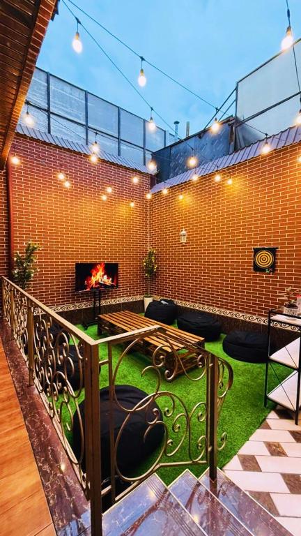 a living room with a fireplace and a green floor at Palm Hostel in Tashkent