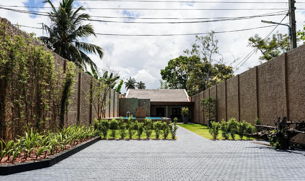 a garden with a brick wall and a courtyard at Villa R in Negombo