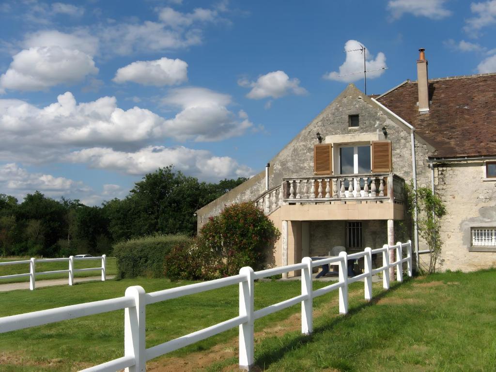 an old house with a white fence at Haras de la fontaine Datcha in Poligny
