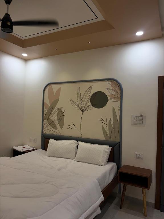 a bedroom with a large bed with a painting on the wall at Hotel Amora in Dighori Buzurg