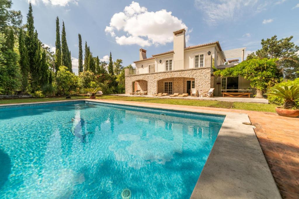 a large swimming pool in front of a house at Villa Alegria in Azeitao