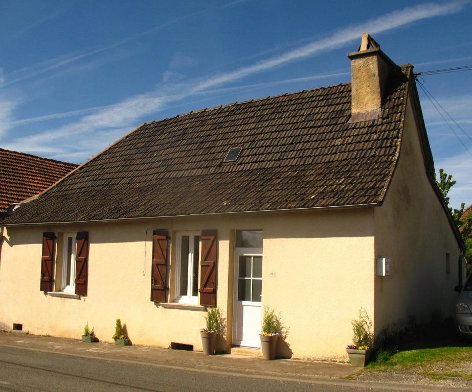 a white house with a brown roof at Le Cosy Nid in Leyme