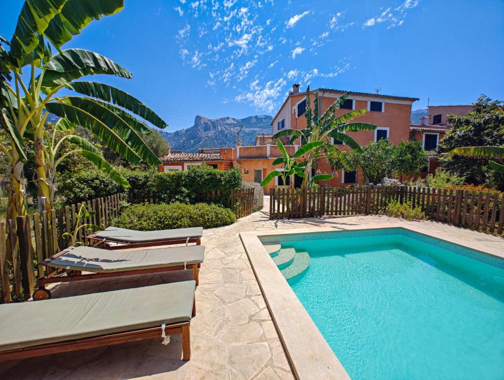 a swimming pool with lounge chairs and a house at S'abeurada con piscina en Soller in Sóller
