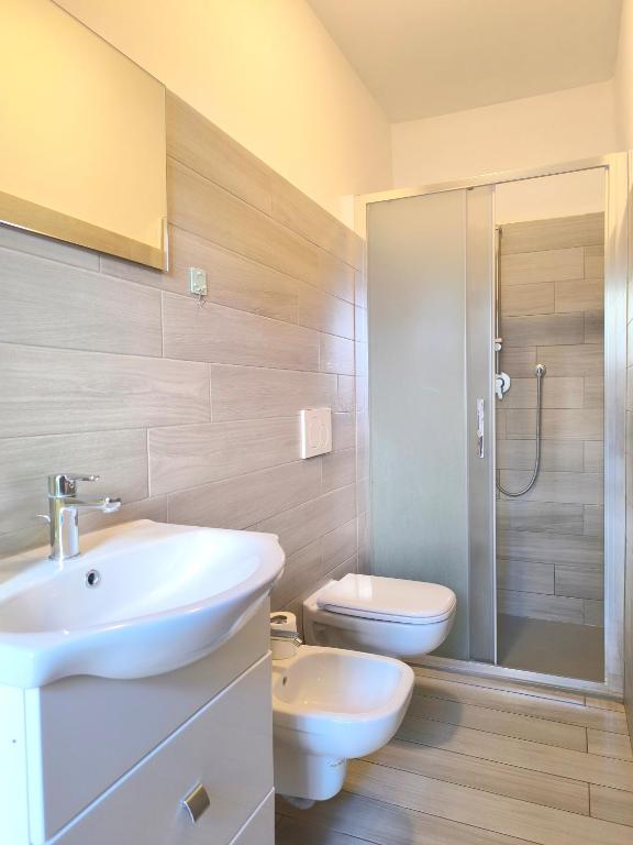 a bathroom with a sink and a toilet and a shower at Levico Antiche Terme Apartment in Levico Terme