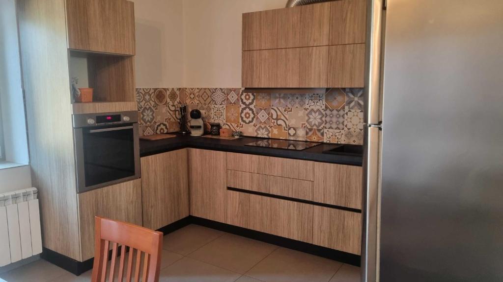 a kitchen with wooden cabinets and a stainless steel refrigerator at Appartamento Trezzo sull'Adda in Trezzo sullʼAdda