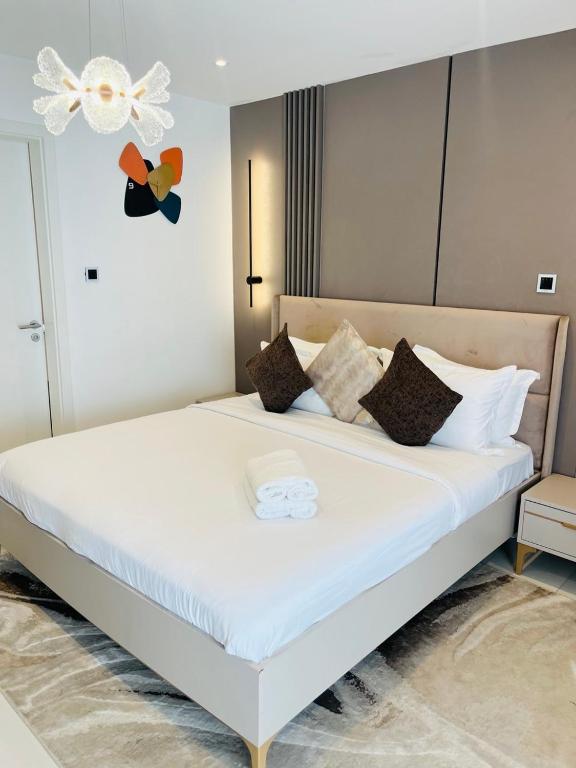 a bedroom with a large white bed with pillows at Nomah Homes The Bantree in Accra