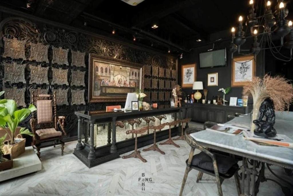 a room with a table and chairs and a wall at Shade House - Phuket Downtown in Phuket