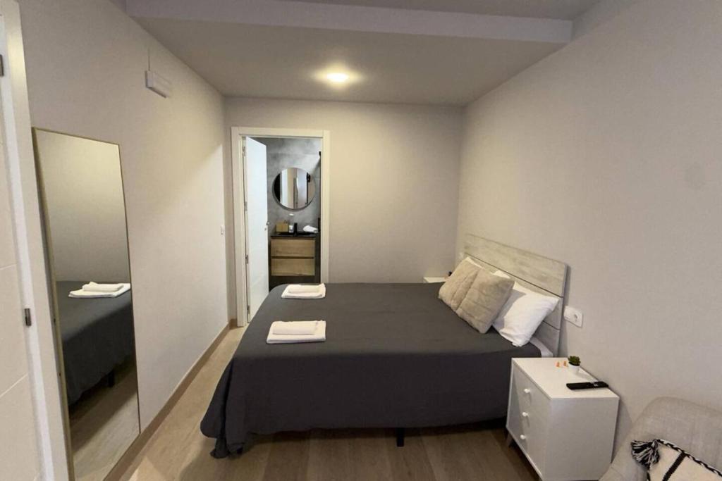 a small bedroom with a bed and a mirror at Suite Muralla 2.3-B in Lugo