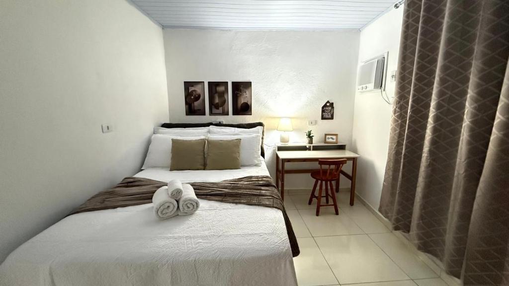 two beds in a small room with a table at Casa no Vidigal da Nilda in Rio de Janeiro