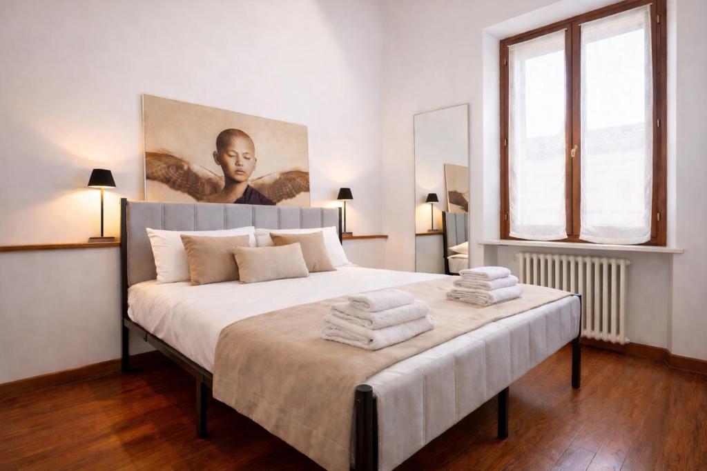 a bedroom with a large bed with towels on it at Dimora Oberdan 1800 - Duplex 70m from Arena 6 Beds in Verona