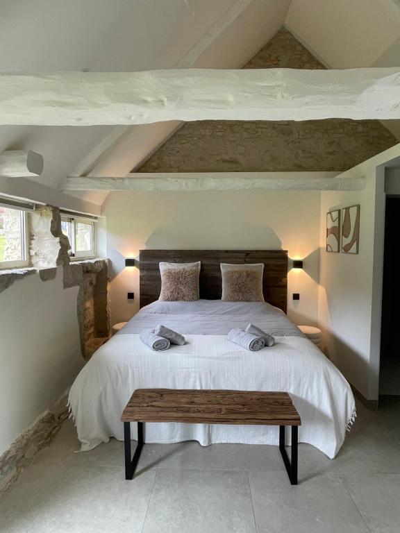 a bedroom with a large bed and a wooden table at Mas de Méjas Chambre d'hôtes La Pierraille in Calvignac