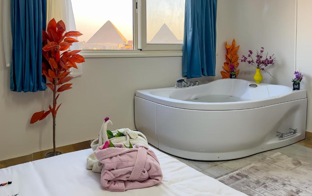 a bathroom with a bath tub and a sink at locanda pyramids view & Jacuzii in Cairo