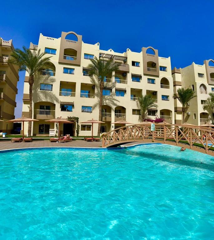 a swimming pool in front of a large building at Studio at El Karma Beach & Aqua Park in Hurghada