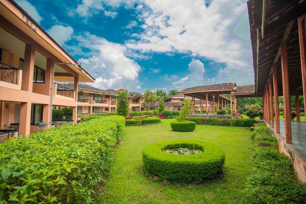 a garden with bushes and a fountain in a courtyard at The International Centre Goa in Panaji