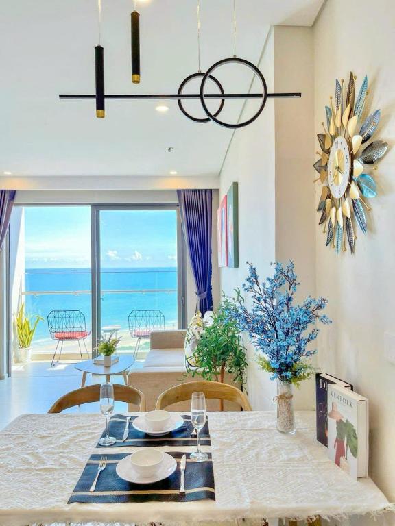 a dining room with a table and a view of the ocean at Ngân Nguyễn Apartment - The Sóng Vũng Tàu in Vung Tau