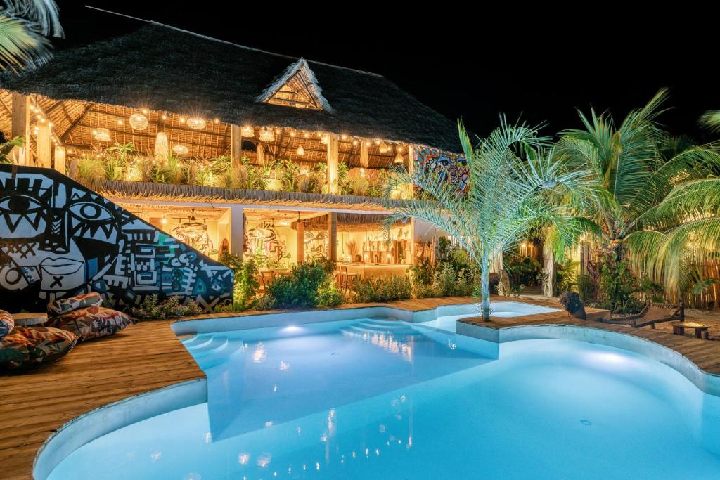ein Haus mit Swimmingpool bei Nacht in der Unterkunft Oke Ani Boutique Hotel in Paje
