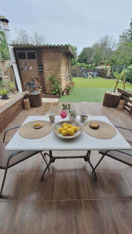 a table with plates of fruit on it on a patio at Glossy Messinian Escape - Cozy Yard Apartment in Filiatra