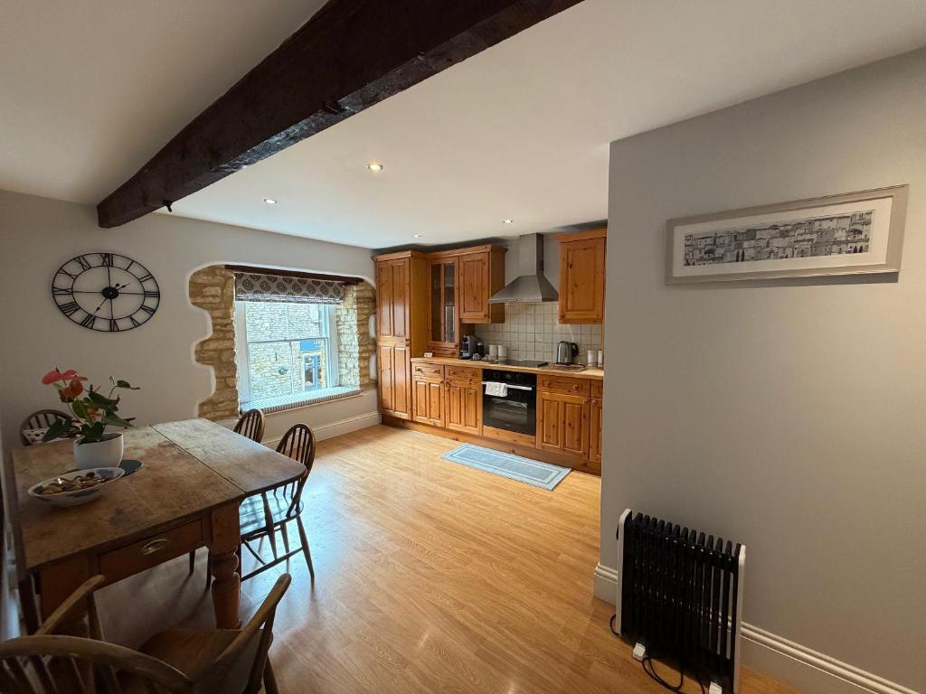 a kitchen and dining room with a table and chairs at Central Stow Bakehouse Flat in Stow on the Wold
