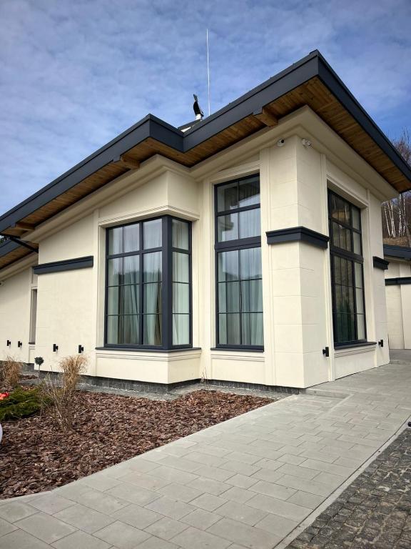 a white house with black windows at Sungora sun&ski resort in Slavske