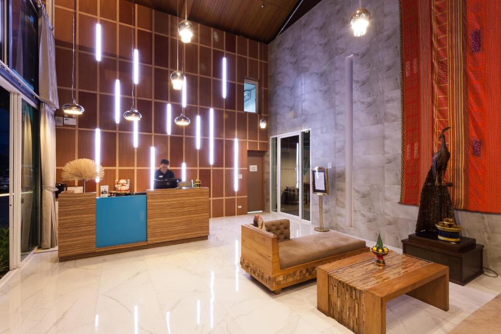 A polished lobby combines a reception counter with low wooden seating and dramatic wall lighting.