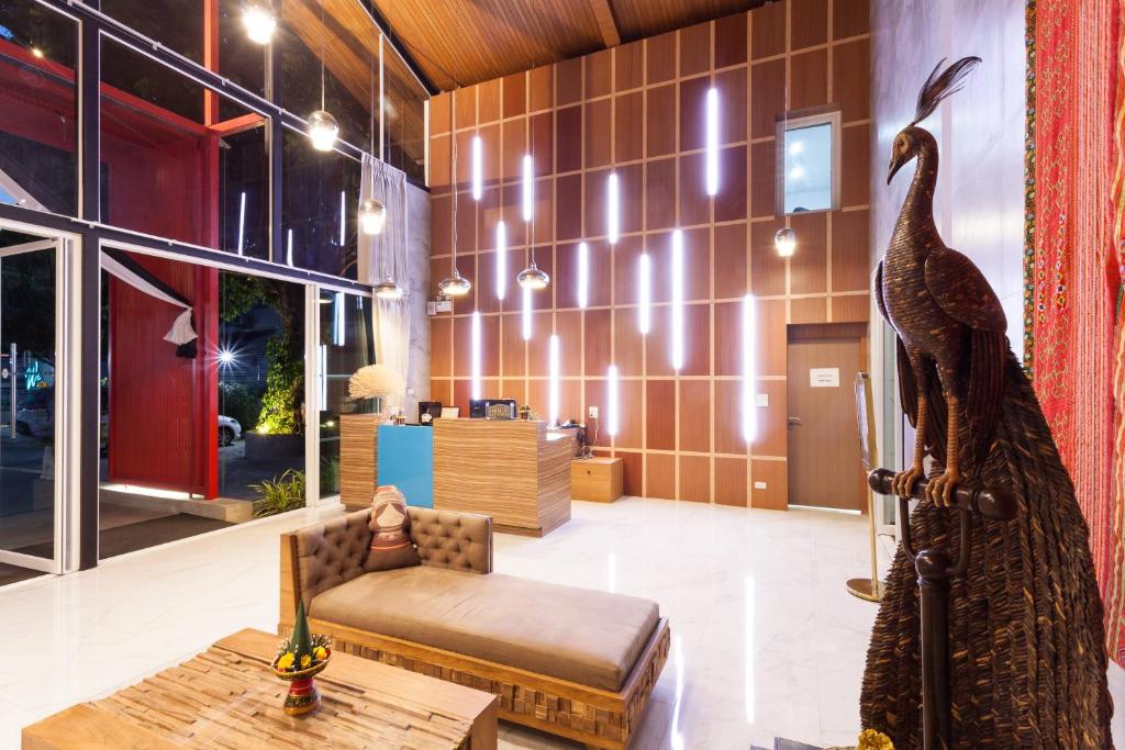 A dramatic reception lobby with a tall peacock sculpture, lounge seating and a reception desk.