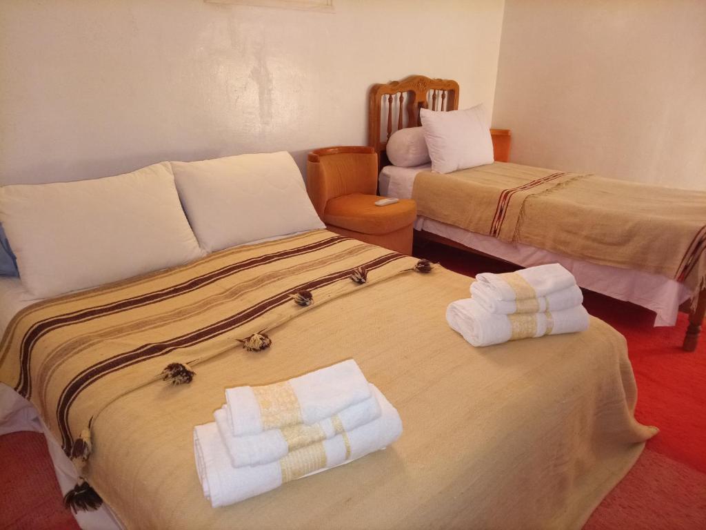 a hotel room with two beds with towels on them at Palmas Magramane Ogandou in Skoura