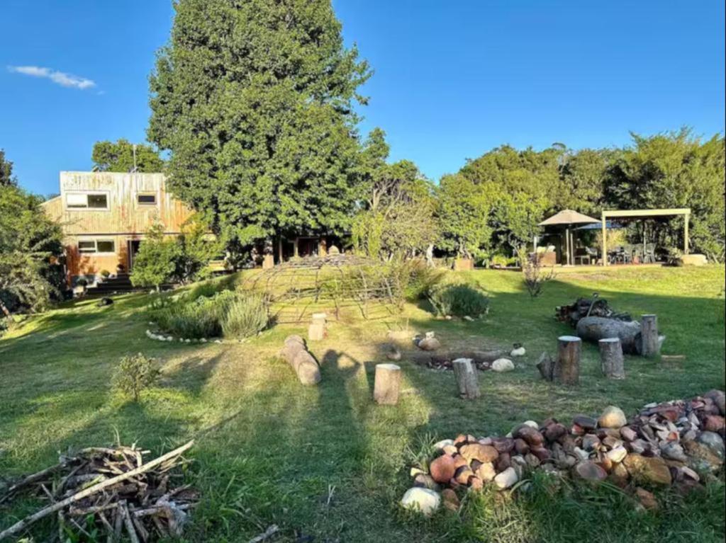 a yard with a pile of rocks in the grass at River Star Retreat in Zuurbraak