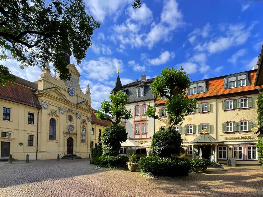 a group of buildings in a courtyard with trees at RomanticHOTEL Goldener Karpfen - das kleine, feine Grandhotel direkt in der Altstadt in Fulda
