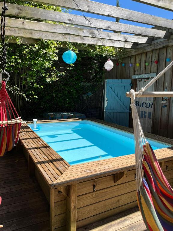 a swimming pool with a swing and a hammock at La Cabane Bordeaux St Augustin in Mérignac