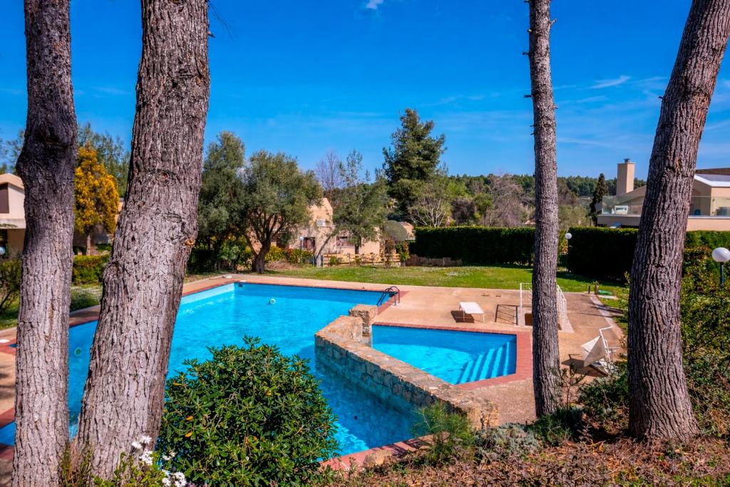 a swimming pool in a yard with trees at Magnolia bliss Calm & Cozy Villa, Sani in Sani Beach
