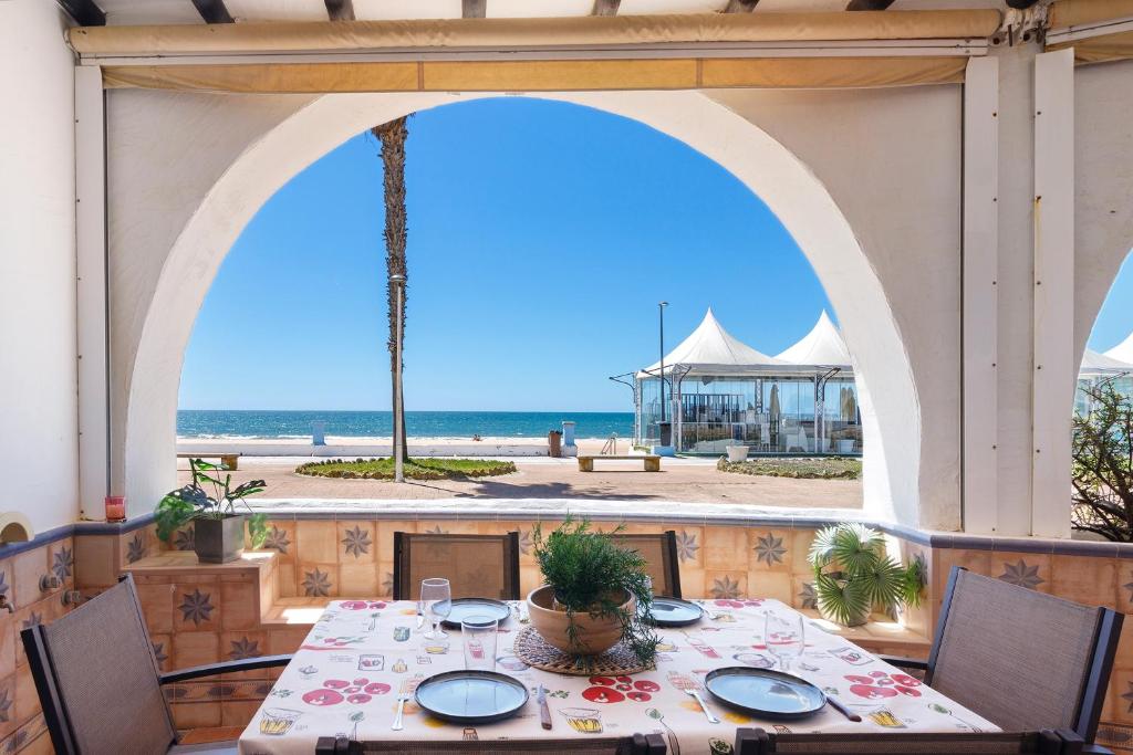 a table on a patio with a view of the beach at Matalascañas Primera Línea de Playa in Matalascañas