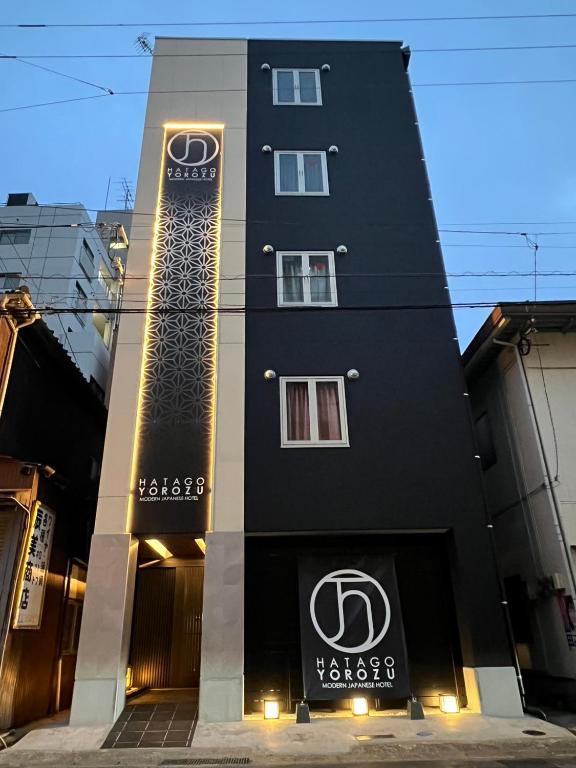 a black building with a sign on the side of it at Hatagoyorozu in Sasebo