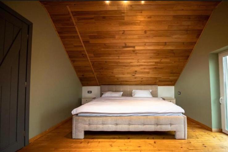 a bed in a room with a wooden ceiling at Guesthouse340 in Roman