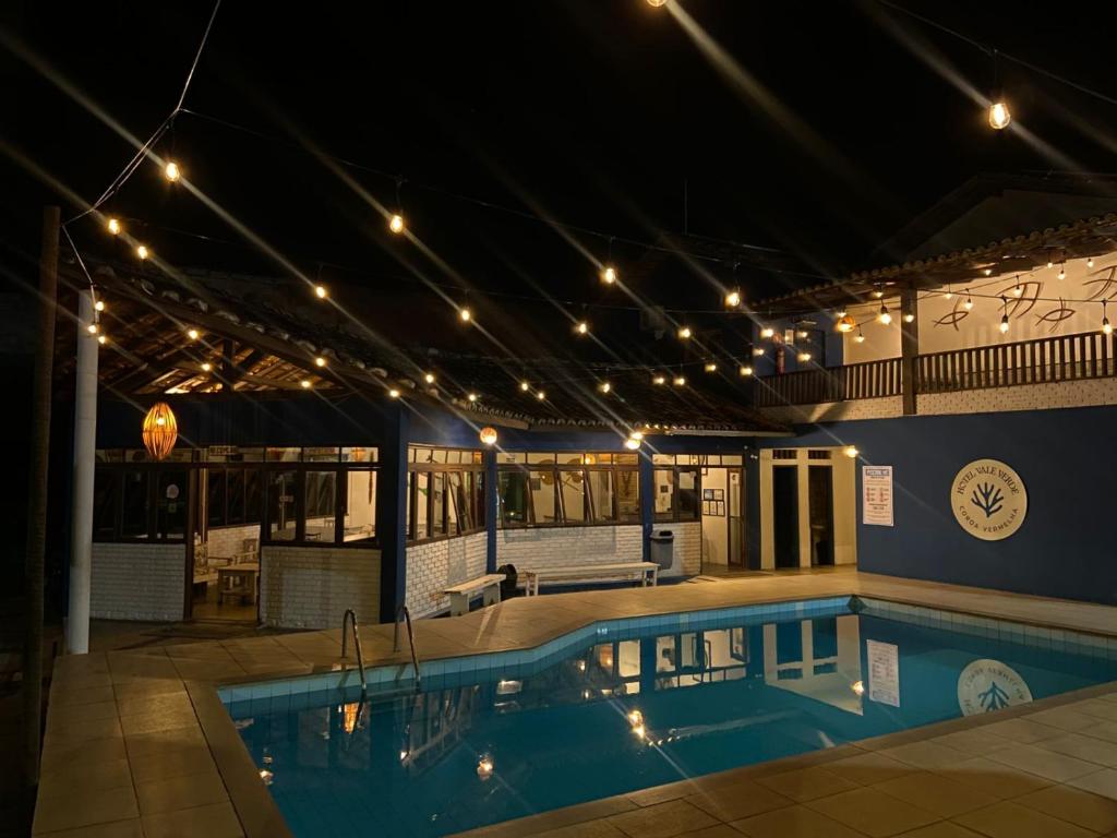 ein beleuchtetes Schwimmbad in einem Gebäude in der Unterkunft Hotel Vale Verde Coroa Vermelha in Santa Cruz Cabrália
